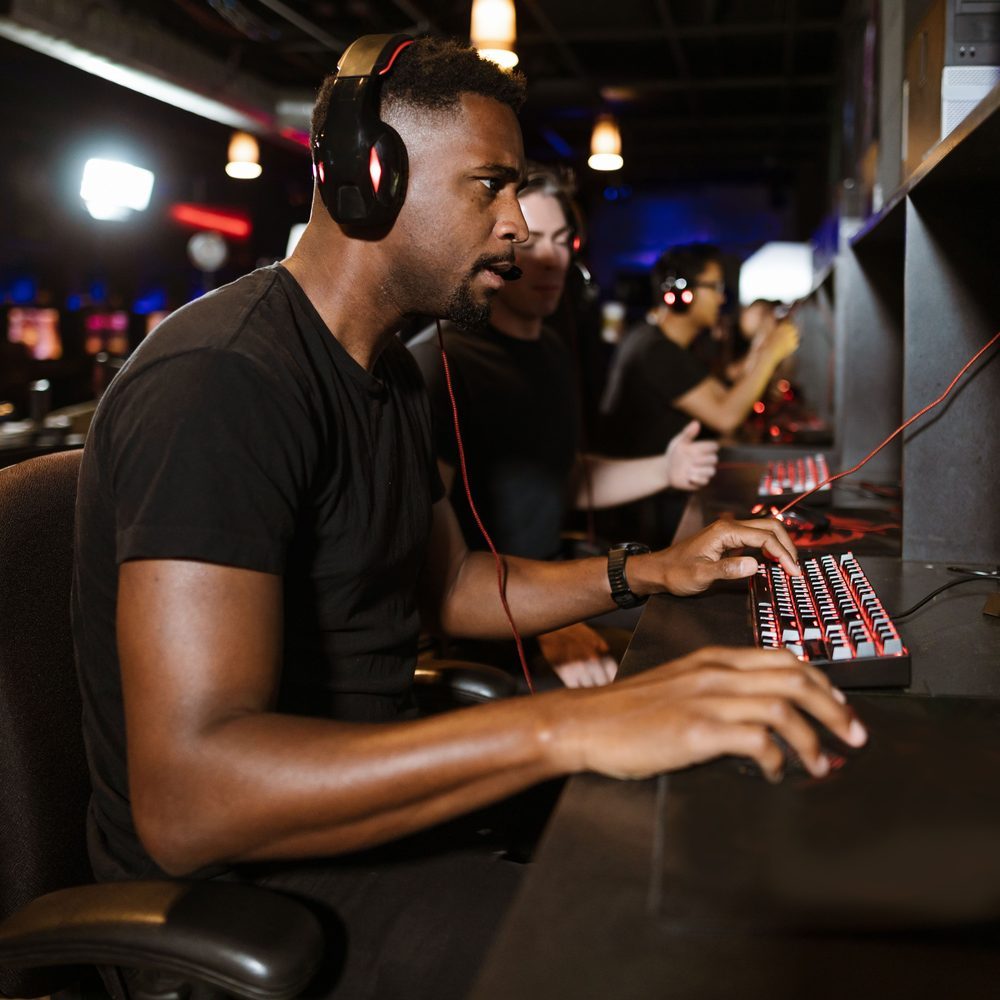 A dim late-hours room with a single deep armchair angled toward a gaming PC
