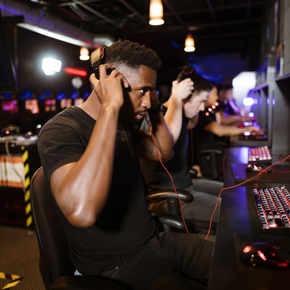 A wider room with a row of gaming PCs and a curved bench that seats a small group